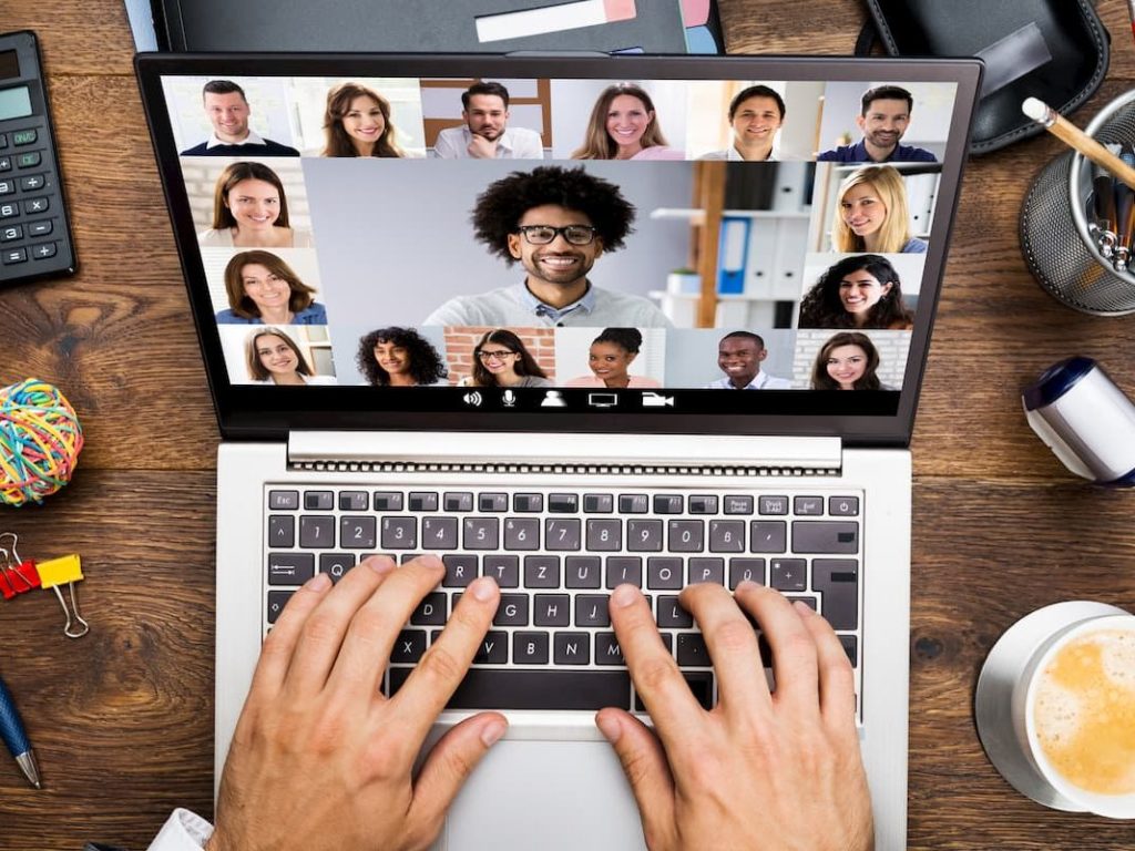 Person typing on a laptop while on a virtual meeting